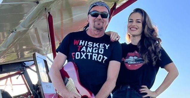 Wykonawcy utworu "Wolnym być" stoją przed samolotem na lotnisku.